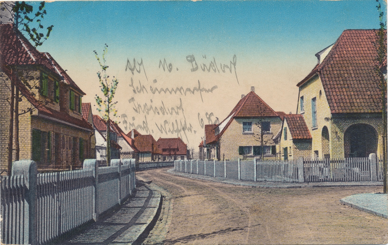 Bilderbuchhafte Häuserreihe mit weißen Zäunen und roten Dächern.