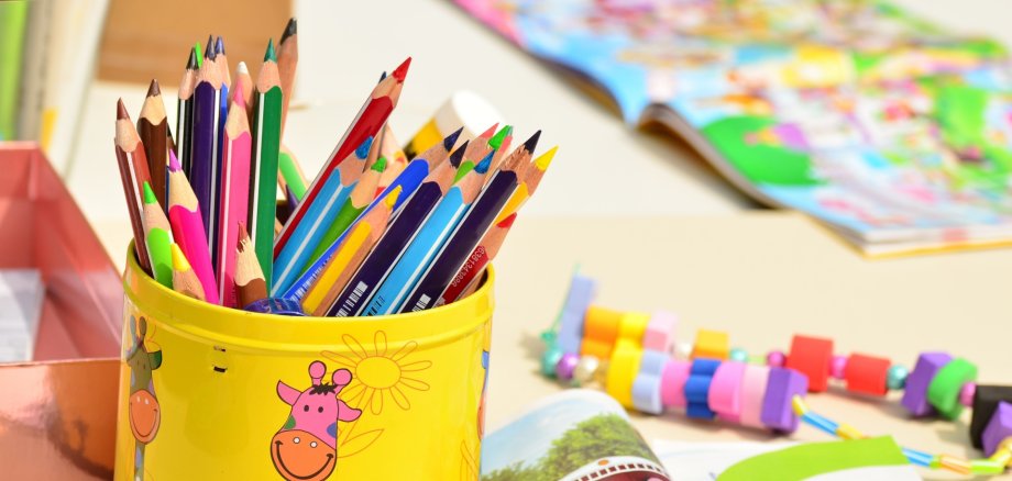 Buntstifte in einer gelben Dose, Kindergartentisch