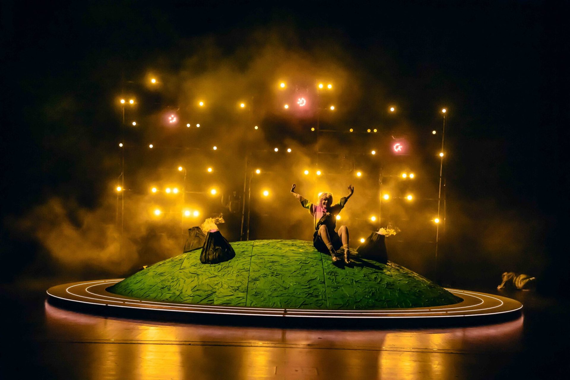 Die Schauspieler des Stücks der kleine Prinz stehen während der Aufführung auf einem grünen "Planeten" auf der Bühne