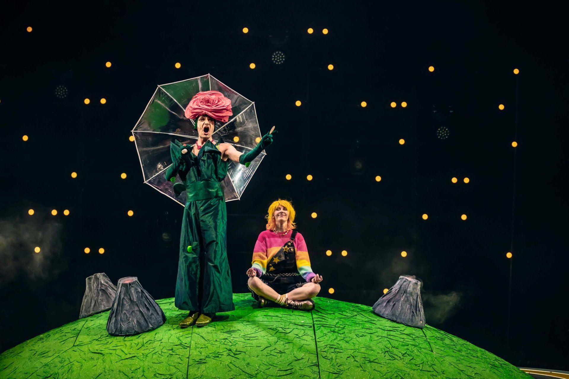 Die Schauspieler des Stücks der kleine Prinz stehen während der Aufführung auf einem grünen "Planeten" auf der Bühne