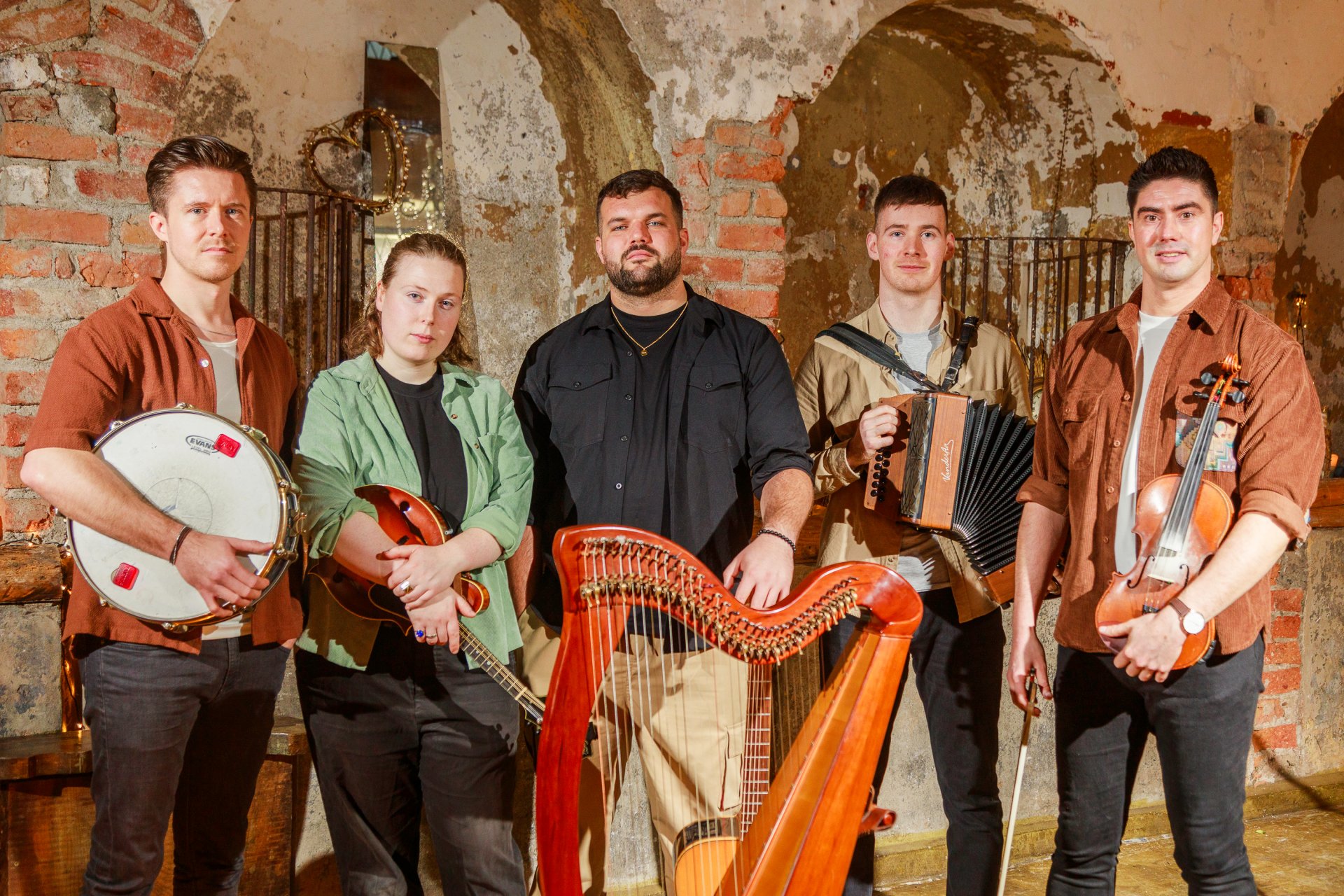 Billow Wood; 5-köpfige Band mit Instrumenten vor steiniger Backstein-Wand