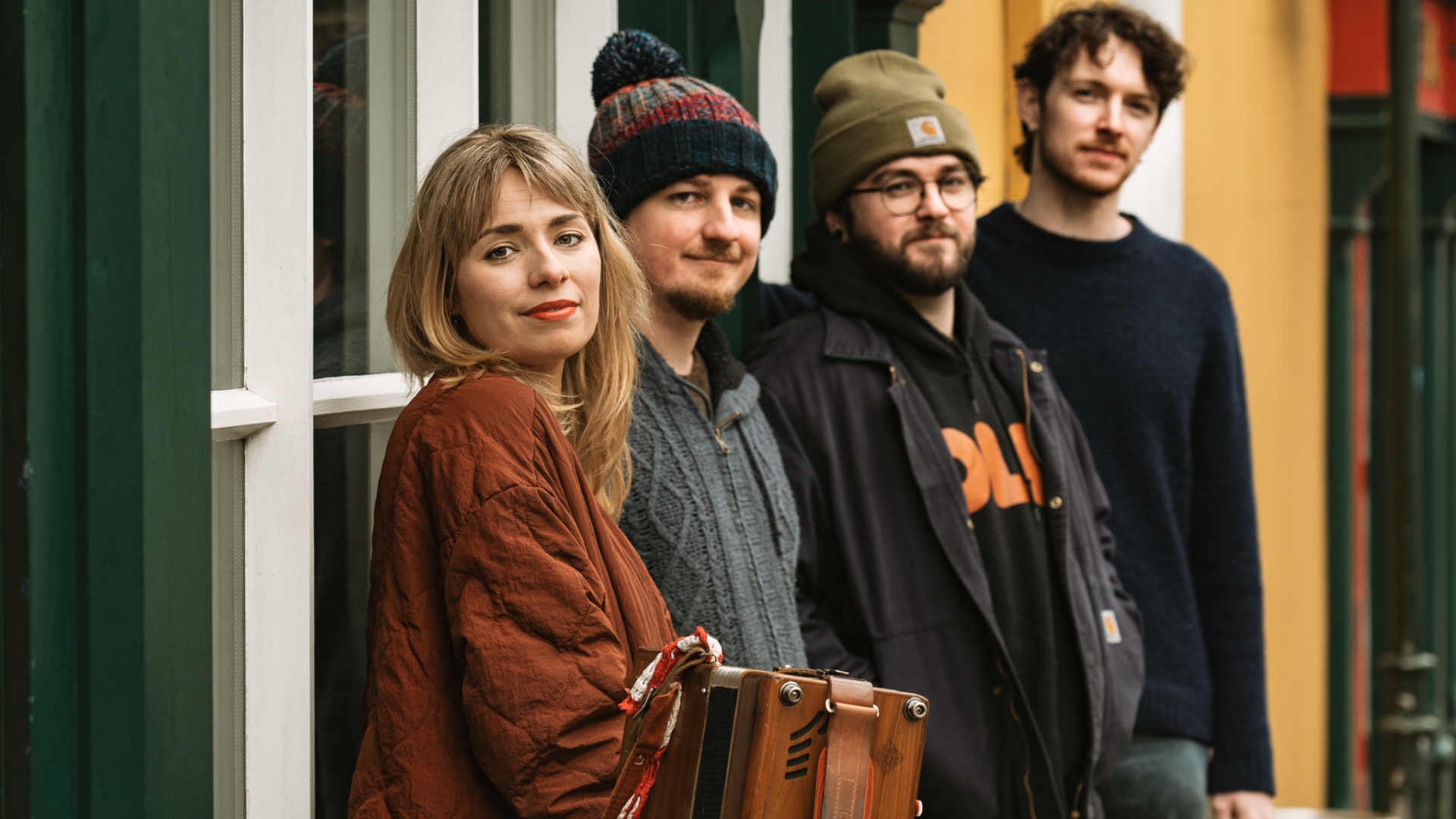 Eva Coyle Band, 4-köpfige Band, hintereinander eingereit an einer Hauswand lehnen