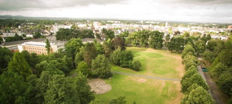 Blick über den Burgpark mit Wiese, Labyrinth und Burgallee vom Dach der Burg Wissem