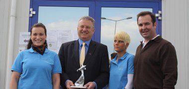 Bürgermeister begutachtet Preis, neben ihm Tölke und Uerdingen von West Golf.