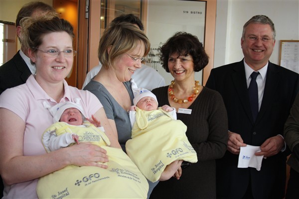 Überraschte Mütter: Maren Schmidt mit Nina (links) und Melanie Grünfeld mit Moritz freuten sich zusammen mit Bürgermeister Klaus-Werner Jablonski (rechts) sowie Vertreterinnen beider Krankenhäuser.