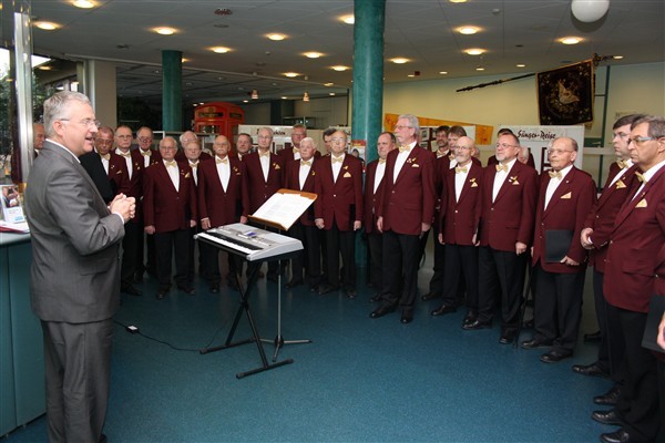 55 Sänger brachten dem Bürgermeister ein Ständchen im Rathaus im Rahmen einer Ausstellung.