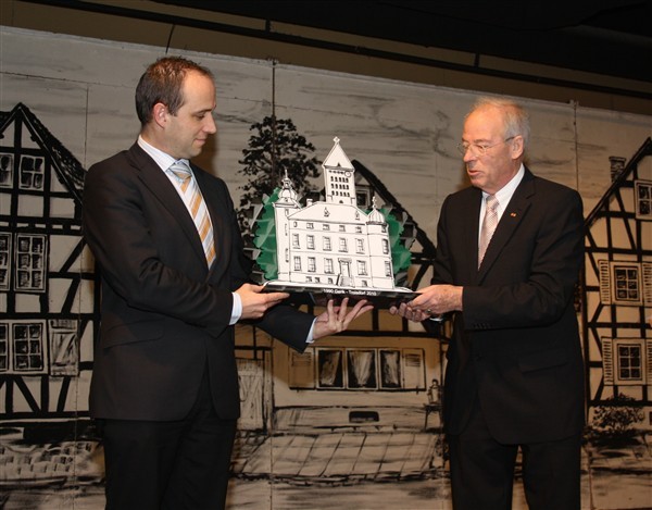 Kunstwerk aus Kunststoff: Vize-Bürgermeister Manfred Catrin (rechts) überreicht Bürgermeister Wim Dries das Jubiläumsgeschenk.