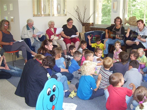 Fröhlich gemeinsam gesungen: Seniorinnen und Senioren, Kinder und Erzieherinnen im Familienzentrum.