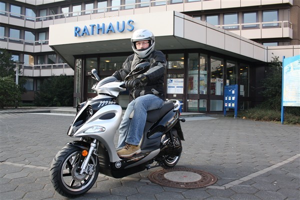 Rathaus umweltfreundlich mobil: Städtischer Mitarbeiter Roland Schreckenberg freut sich auf Fahrten mit dem neuen Elektro-Roller.