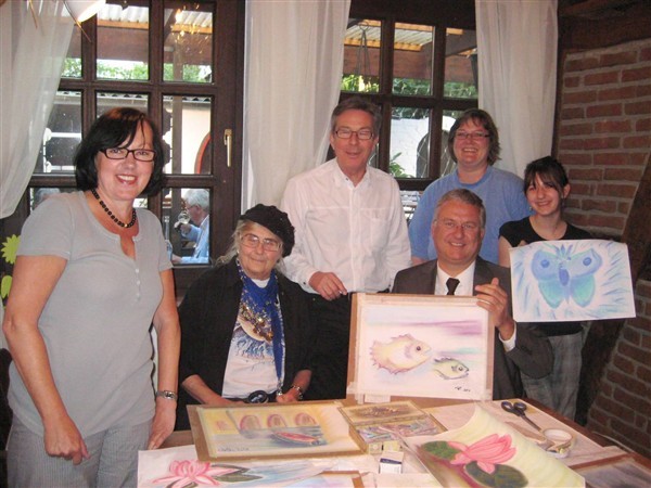 Freude über Bilder und Spende: Bürgermeister Klaus-Werner Jablonski (Mitte) mit Künstlerin Ri Meuser, stehend Weinstuben-Wirt Rolf Alfter und Teilnehmerinnen des Pastell-Kurses.
