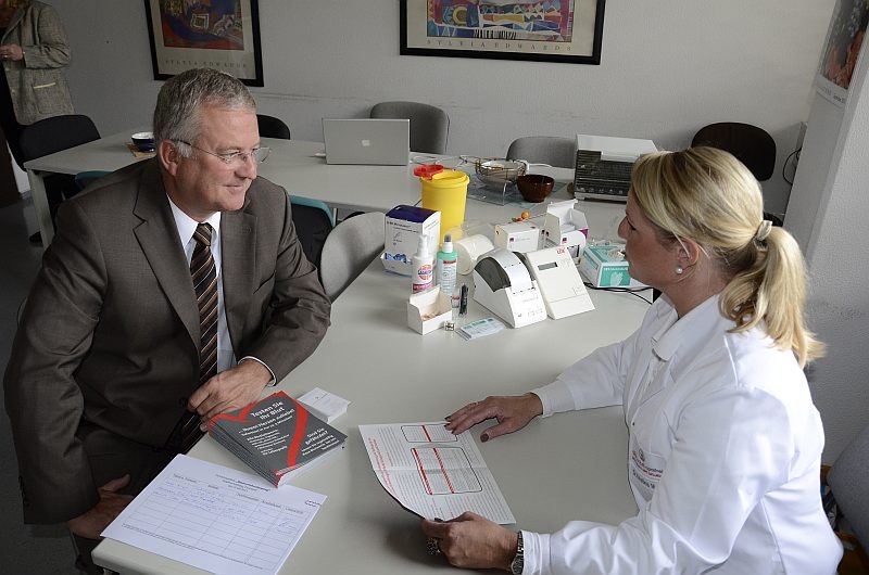 Minutenschnell wissen, ob alles im grünen Bereich ist: Apothekerin Dr. Kristina Meurer erläutert dem Troisdorfer Bürgermeister Klaus-Werner Jablonski den Blutschnelltest