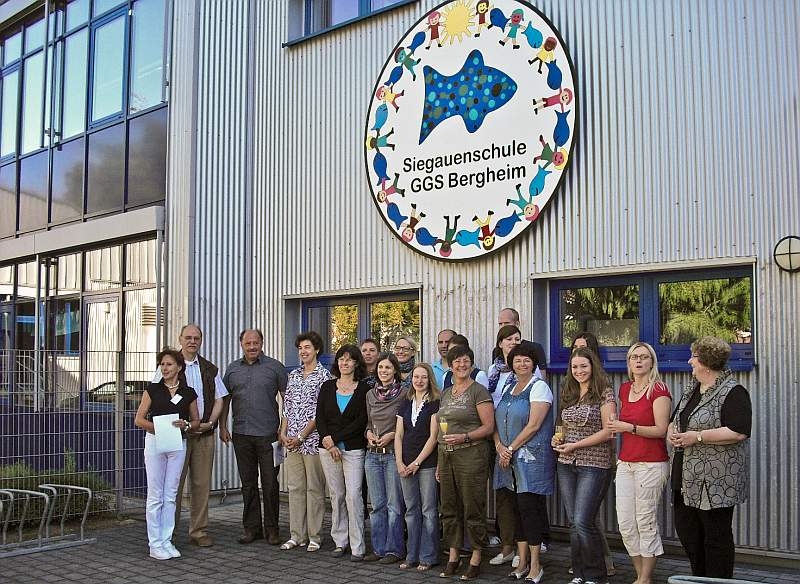 Das Kollegium der Schule und die Gäste mit Schulleiterin Ines Burchardt (links): Ortsvorsteher Karl-Heinz Stocksiefen, Künstler Josef Hawle und Claudia Koppenol, Vorsitzende des Fördervereins.