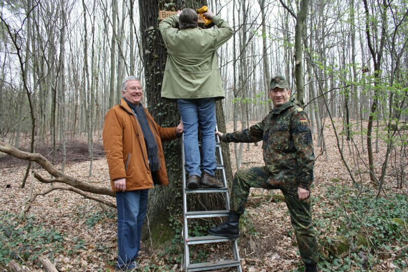 Neue Hinweisschilder aus Holz werden in der Wahner Heide angebracht.