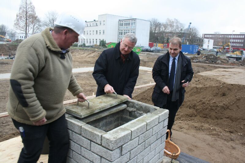 Bürgermeister Jablonski (Mitte) legte den Grundstein für die neue Veranstaltungshalle gegenüber dem Rathaus.