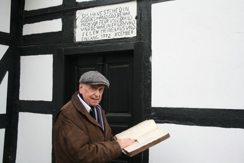 „Dies Haus steht in Gottes Hand…“: Heimathistoriker Kurt P. Schneider zeigt das historische „Hausbuch“ im Hof Larstraße 156 mit der beeindruckenden Inschrift.