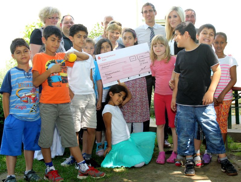 Vertreter der Wohnungsbaugenossenschaft und die Kinder freuten sich gemeinsam am Haus International.