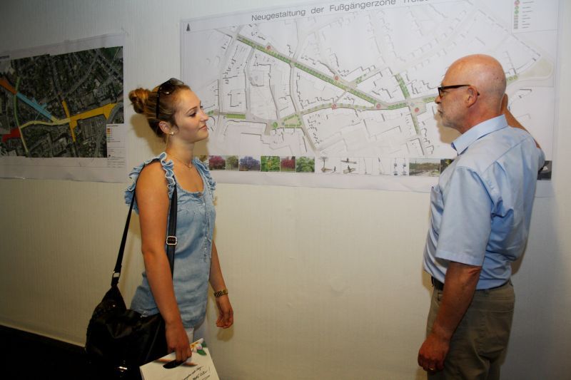 Stadtplaner Claus Chrispeels erläutert einer Passantin die Pläne zur Sanierung der Fußgängerzone.
