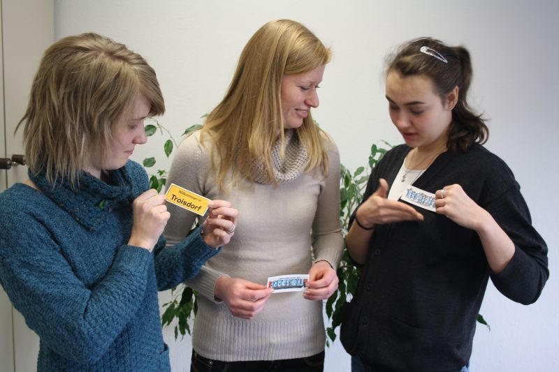 Drei jugne Damen haben die neuen Troisdorf-Aufkleber bereits.