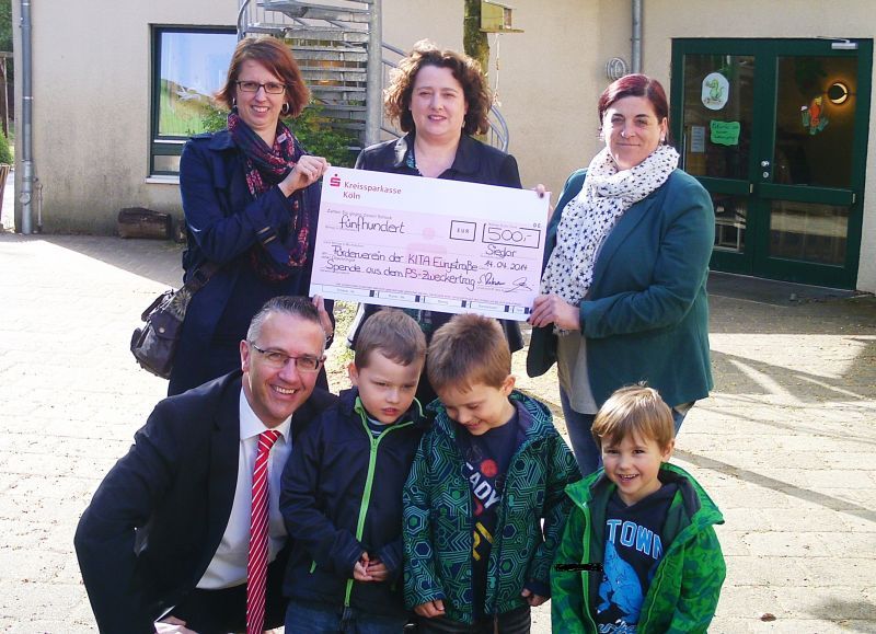 Scheck für Schwarzlicht: stehend v.l. Pia Kemen, Brigitte Klein und Aja Berndt mit Sven Rower und Kindern der Kita Evrystraße