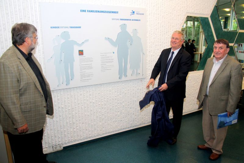 Wandtafel gemeinsam enthüllt: v.l. Peter Wasserfuhr, Bürgermeister Klaus-Werner Jablonski und Werner Zander, Vorsitzender des Seniorenbeirats der Stadt Troisdorf