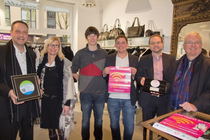 v.l. Dirk Pohlscheidt (Mediata), Stephanie Lottis (Troisdorf Aktiv), Nils Jakobi und Stefan Hoffmann (Freifunk Troisdorf), Thomas Zacharias (Geschäftsführer der TROWISTA) und Bürgermeister Klaus-Werner Jablonski im Modegeschäft Coccinella