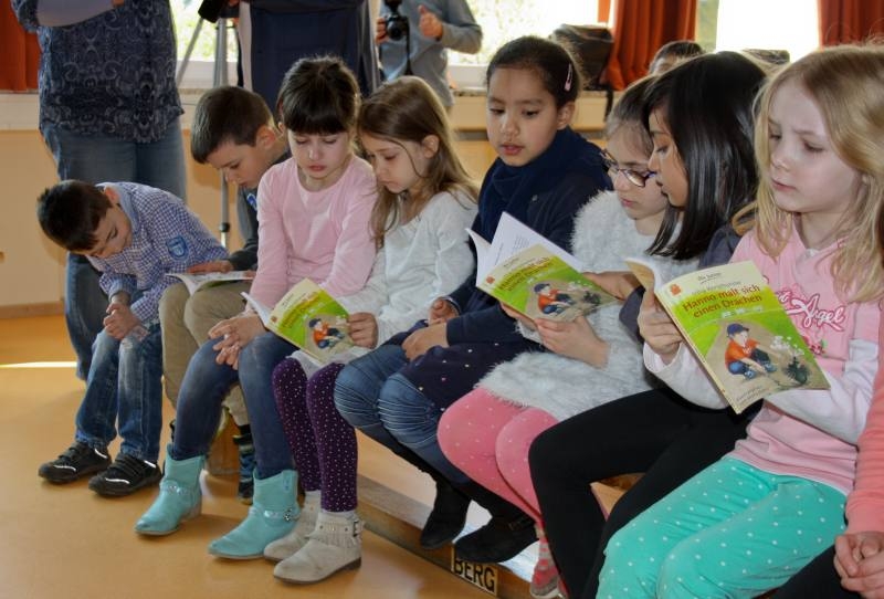 Die Schülerinnen und Schüler blättern neugierig in den Büchern, die sie gerade erhalten haben.
