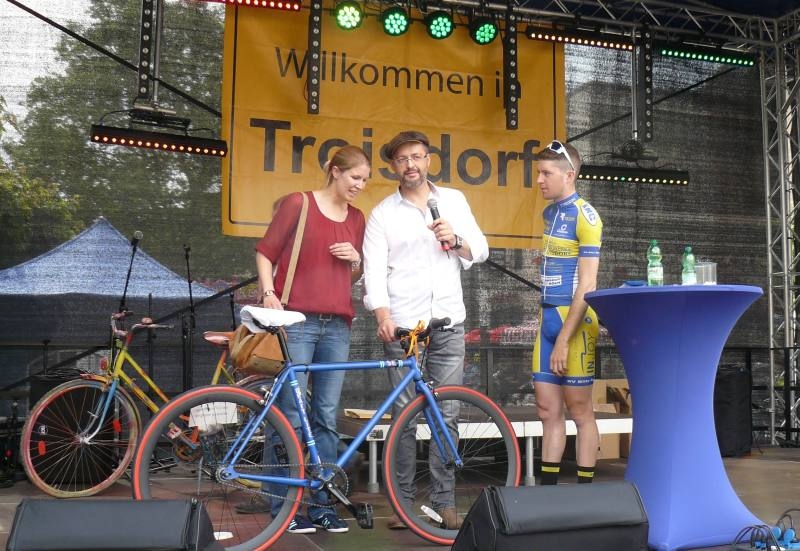 Blaues Rad als 1. Preis: Die Gewinnerin Karin Poppenborg mit Moderator Thorsten Sterzel und Alexander Weifenbach vom RV Blitz Spich.