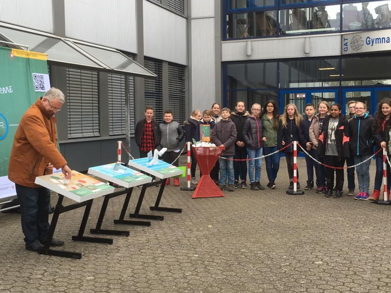 Bürgermeister Klaus-Werner Jablonski am Experimentiertisch. Im Hintergrund die Schüler.