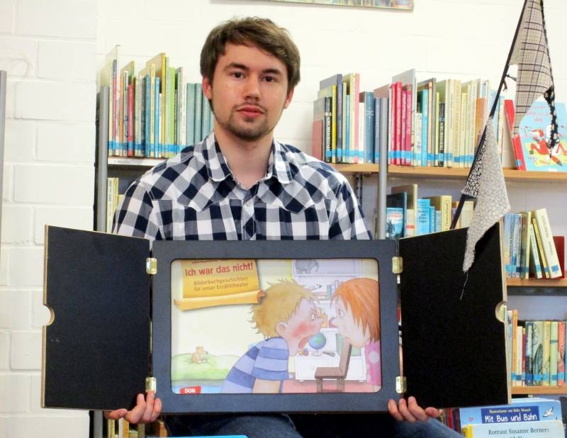 Der Auszubildende zum Fachangestellten für Medien und Informationsdienste (FAMI), Niklas Langen, mit dem „Kamishibai“.
