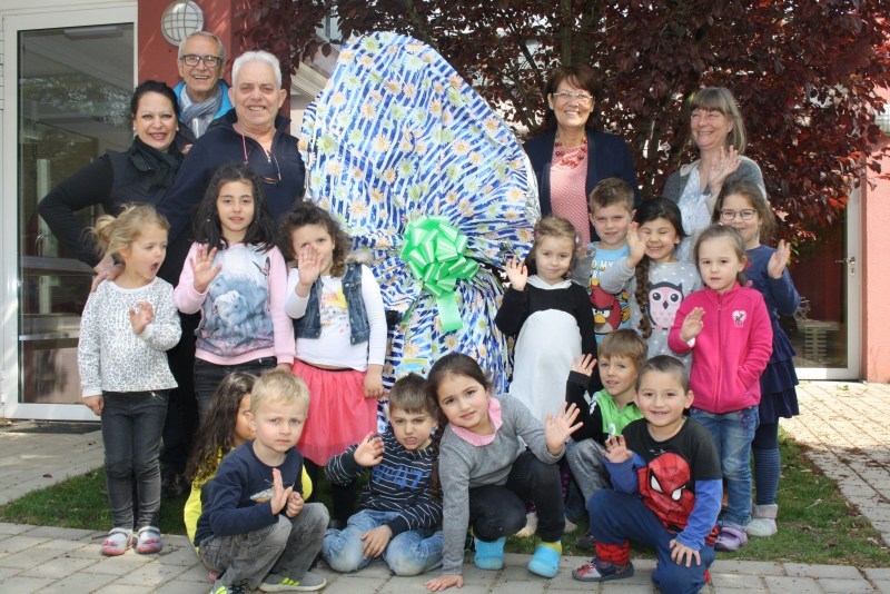 Riesenei in der Kita: Die Kinder mit v.l. Angela und Vito Collura, dahinter Ortsvorsteher Rudolf Eich, Kita-Leiterin Vera Schmitt und Erzieherin Beatrix Hogenfeld.