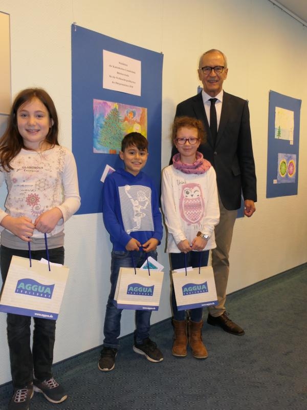 Der stellvertretende Bürgermeister Rudolf Eich mit den Kindern, deren Bilder die Weihnachtskarte des Bürgermeisters schmücken: Mona, Efe und Franziska (von links)