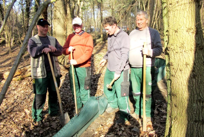 Mitarbeiter des städtischen Bauhofs errichten den Schutzzaun für Kröten an der Asselbachstraße.