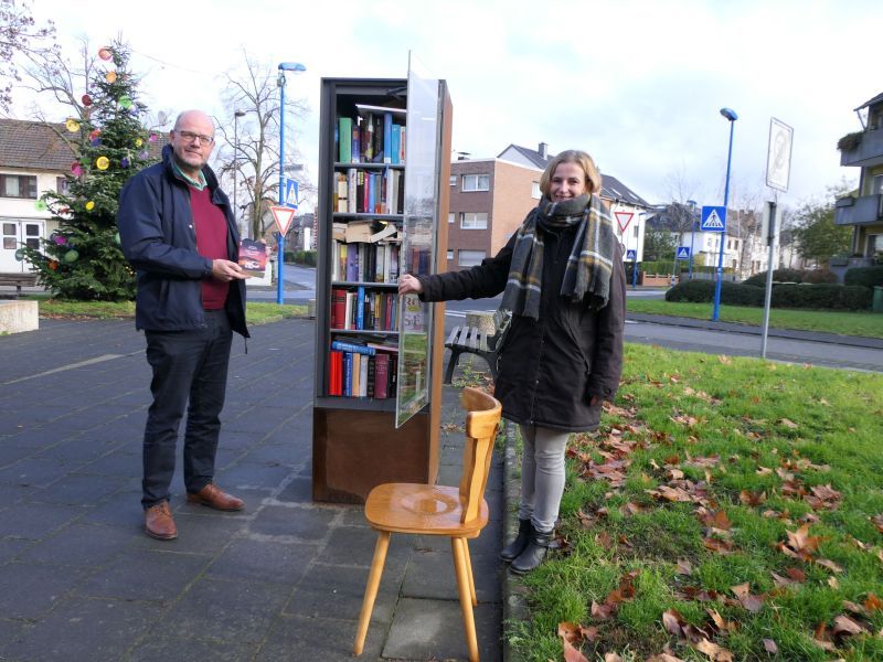 Sandra Stein vom Kulturamt und Beigeordneter Horst Wende am neuen Bücherschrank in Oberlar.
