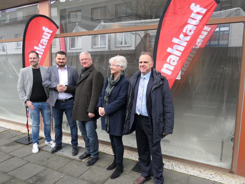 Bürgermeister Klaus-Werner Jablonski (Mitte) vor dem zukünftigen Nahkauf.