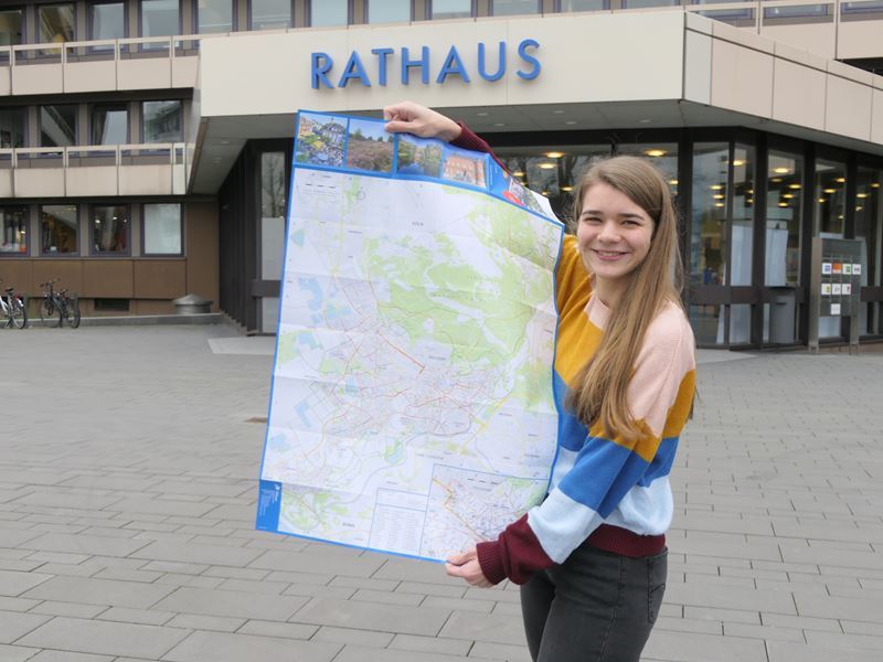Sarah Grunau, Auszubildende zur Veranstaltungskauffrau in der Pressestelle, mit dem neu aufgelegten Stadtplan.