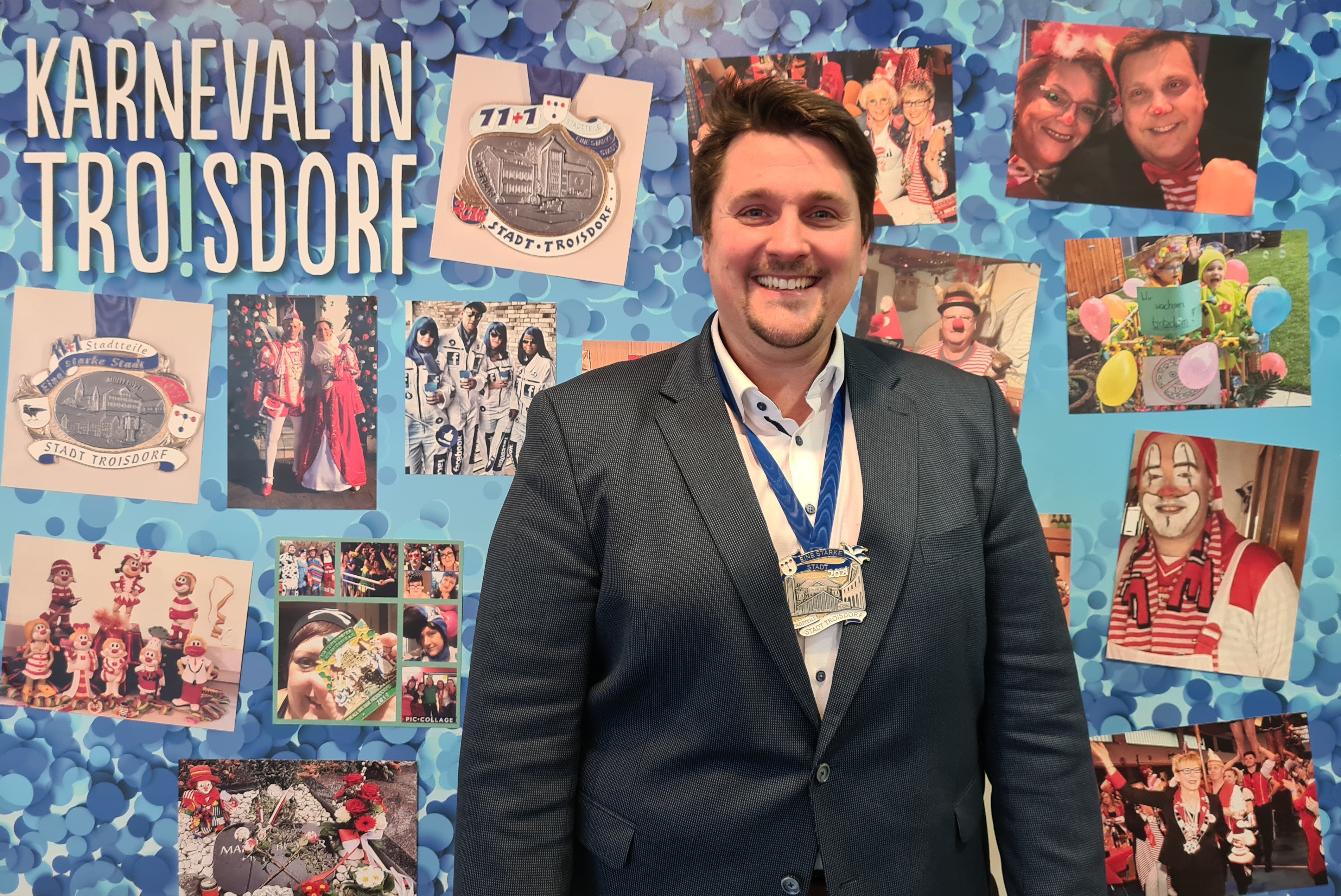 Bürgermeister Biber vor der Foto-Wand. 