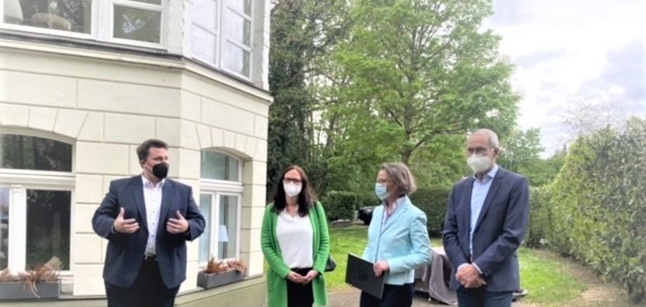 Bürgermeister Biber, MdL Gebauer, Ministerin Scharrenbach und Ortsvorsteher Eich vor Villa Langen.jpg