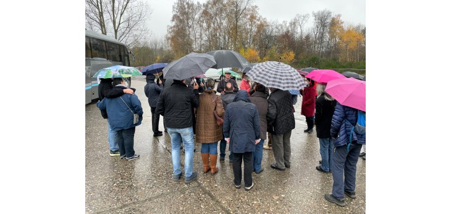 Bustour bei Regen: René Gerber (Mitte) berichtet den Teilnehmern über seine Dienstzeit im Camp Altenrath.