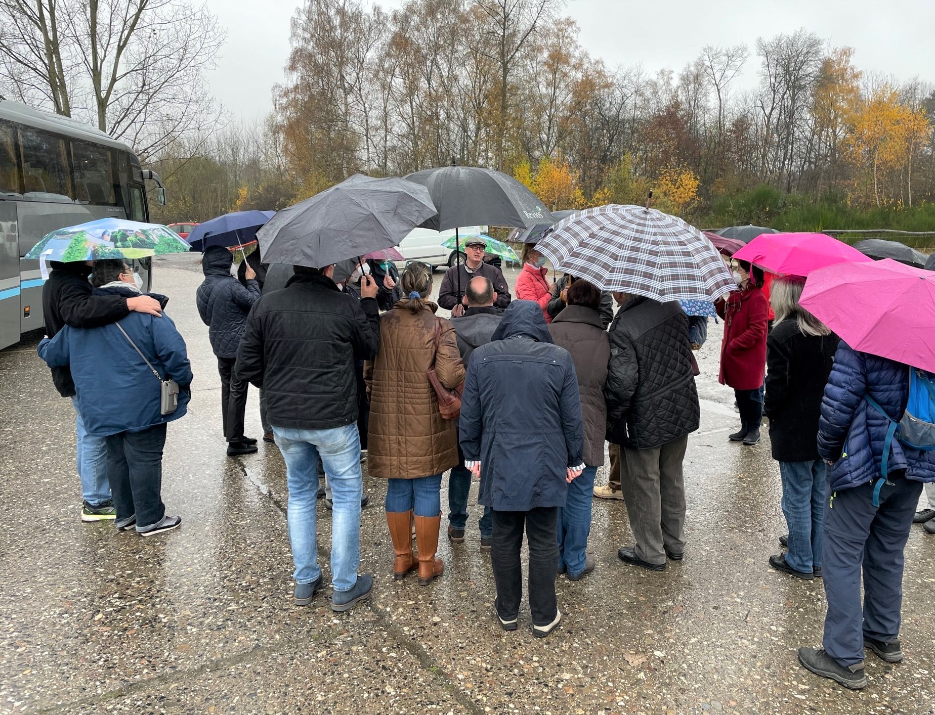 Bustour bei Regen: René Gerber (Mitte) berichtet den Teilnehmern über seine Dienstzeit im Camp Altenrath.
