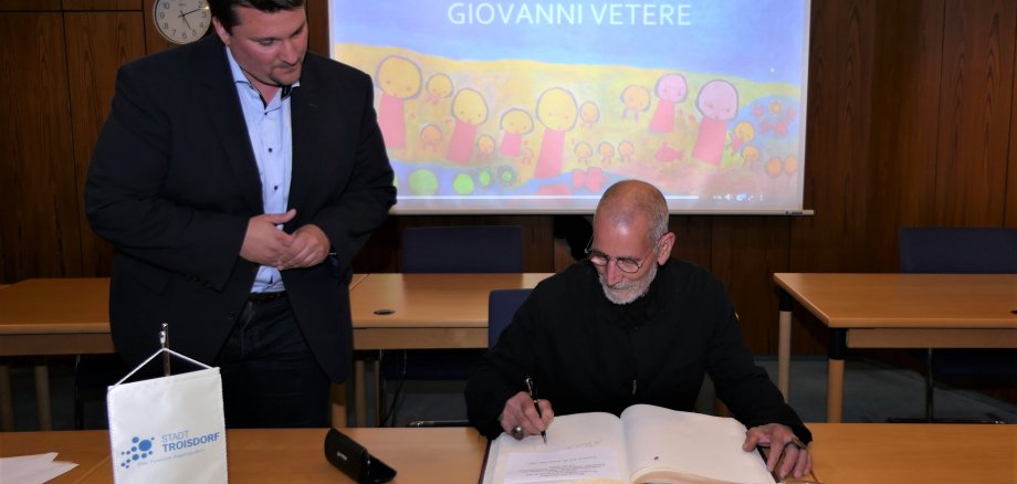 Im Beisein von Bürgermeister Alexander Biber trägt sich Giovanni Vetere ins Goldene Buch ein. 