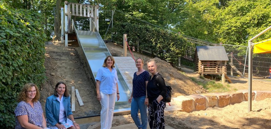 Kita-Leiterin Claudia Lasseur-Au (mitte), ihre Stellvertreterin Martina Assenmacher-Klein (2. v. r.), sowie aus dem Rathaus die Beigeordnete Tanja Gaspers (2. v. l.), Sabine Streeck (r.) und Martina Neuer (l.) begutachten den Baufortschritt auf dem Spielgelände der Kita Flachtenstraße und besprechen künftige Projekte. 