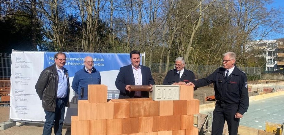 Grundsteinlegung für das Feuerwehrhaus auf der Hütte mit Bürgermeister Biber (mitte).