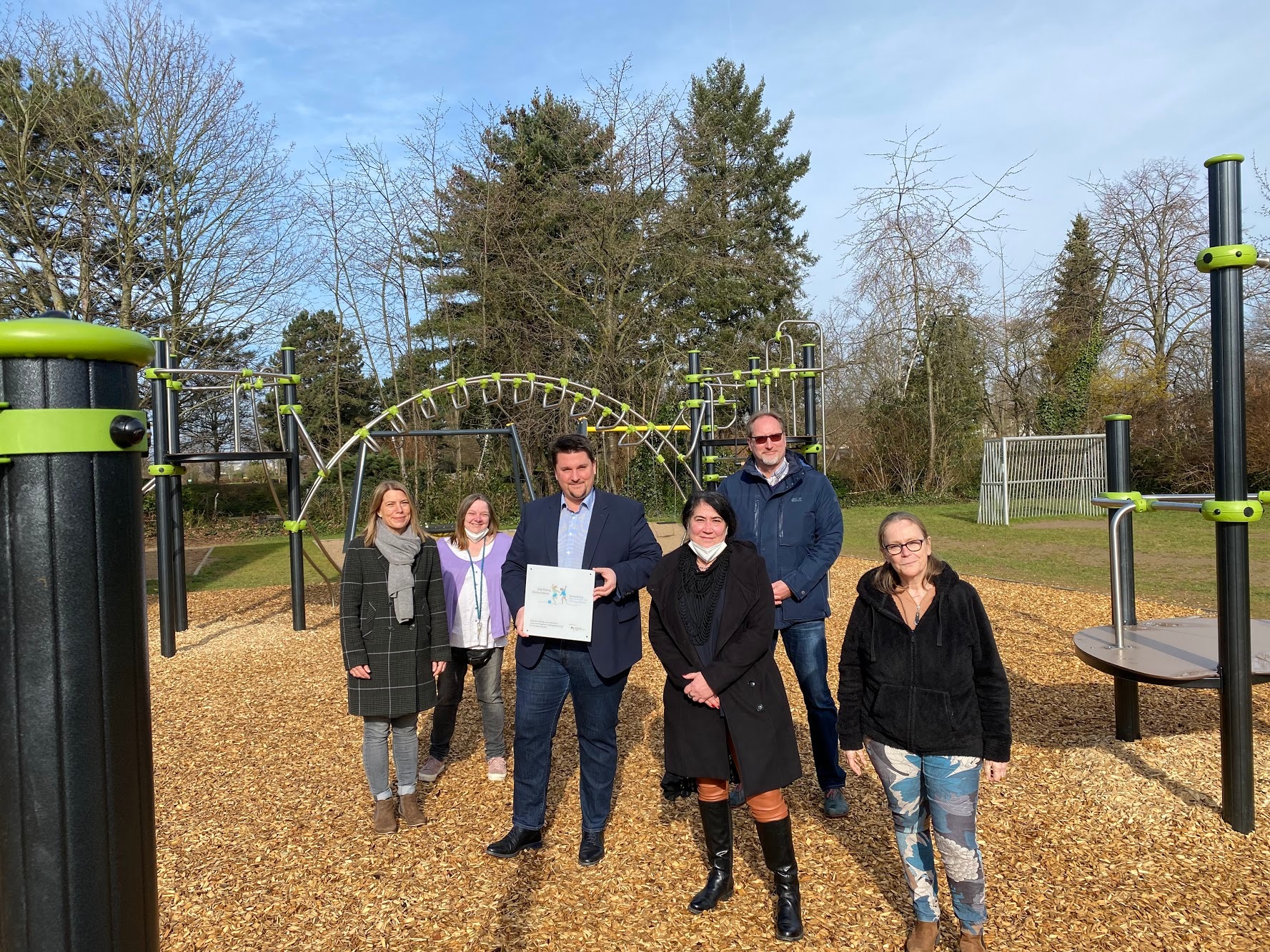 Bürgermeister Alexander Biber mit Vertreten der Schule und der Stadtverwaltung vor den neuen Spielgeräten der Trogata an der Spicher Sternenschule