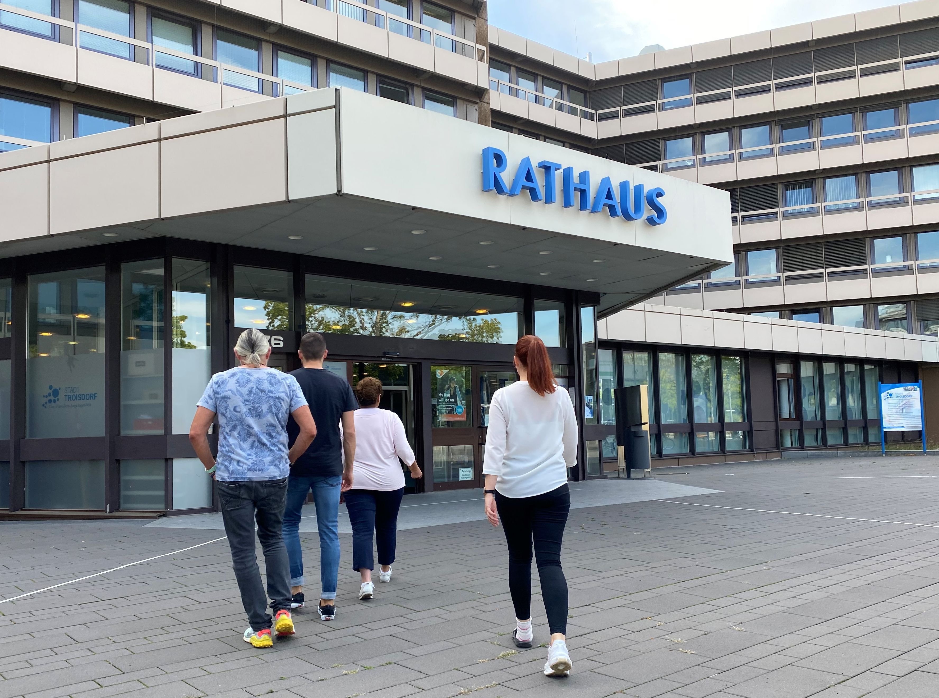 Menschen auf dem Weg ins Rathaus.