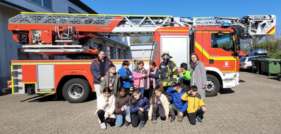 Besuchergruppe aus dem MGH vor der Drehleiter der Feuerwehr