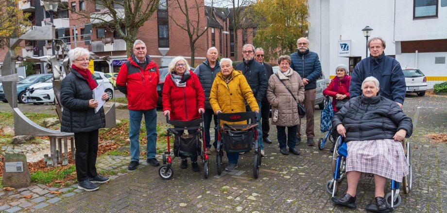 Ältere Menschen und Rollstuhlfahrer stehen im Stadtteil Rotter See