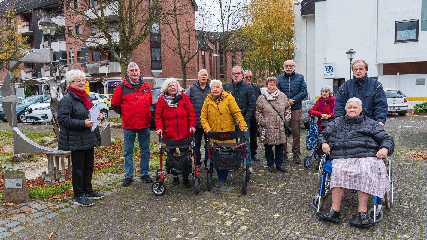 Ältere Menschen und Rollstuhlfahrer stehen im Stadtteil Rotter See