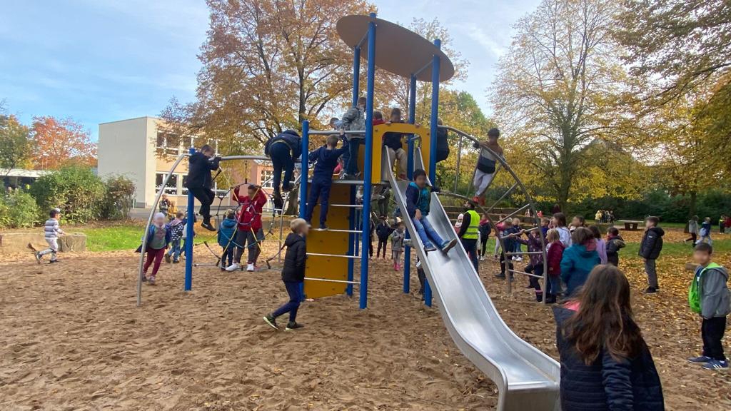 Kinder spielen auf Klettergerüst und Rutsche