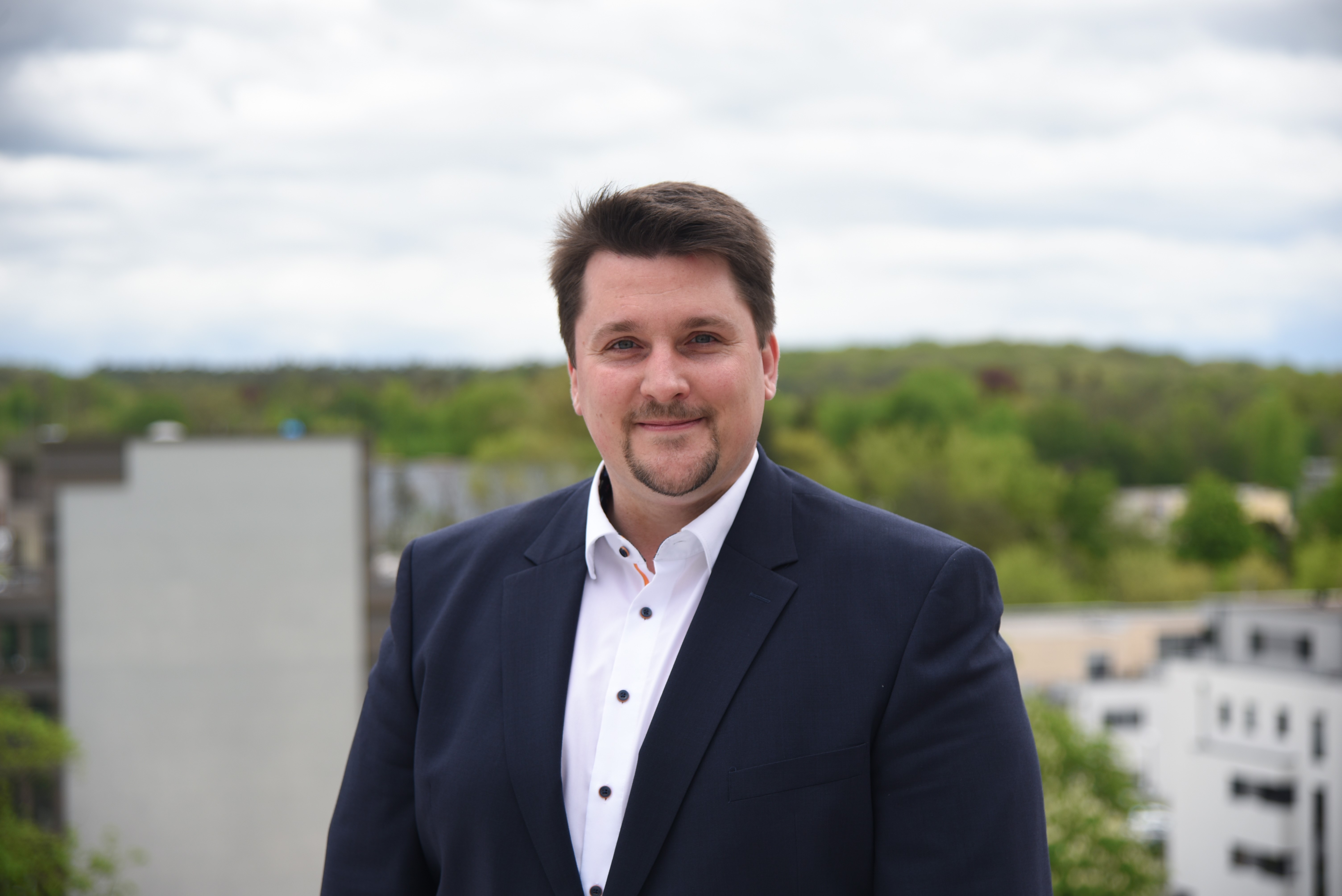 Bürgermeister Biber über den Dächern der Stadt, im Hintergrund hinter der Wohnbebauung erstreckt sich das zum Verkauf stehende Grundstück.