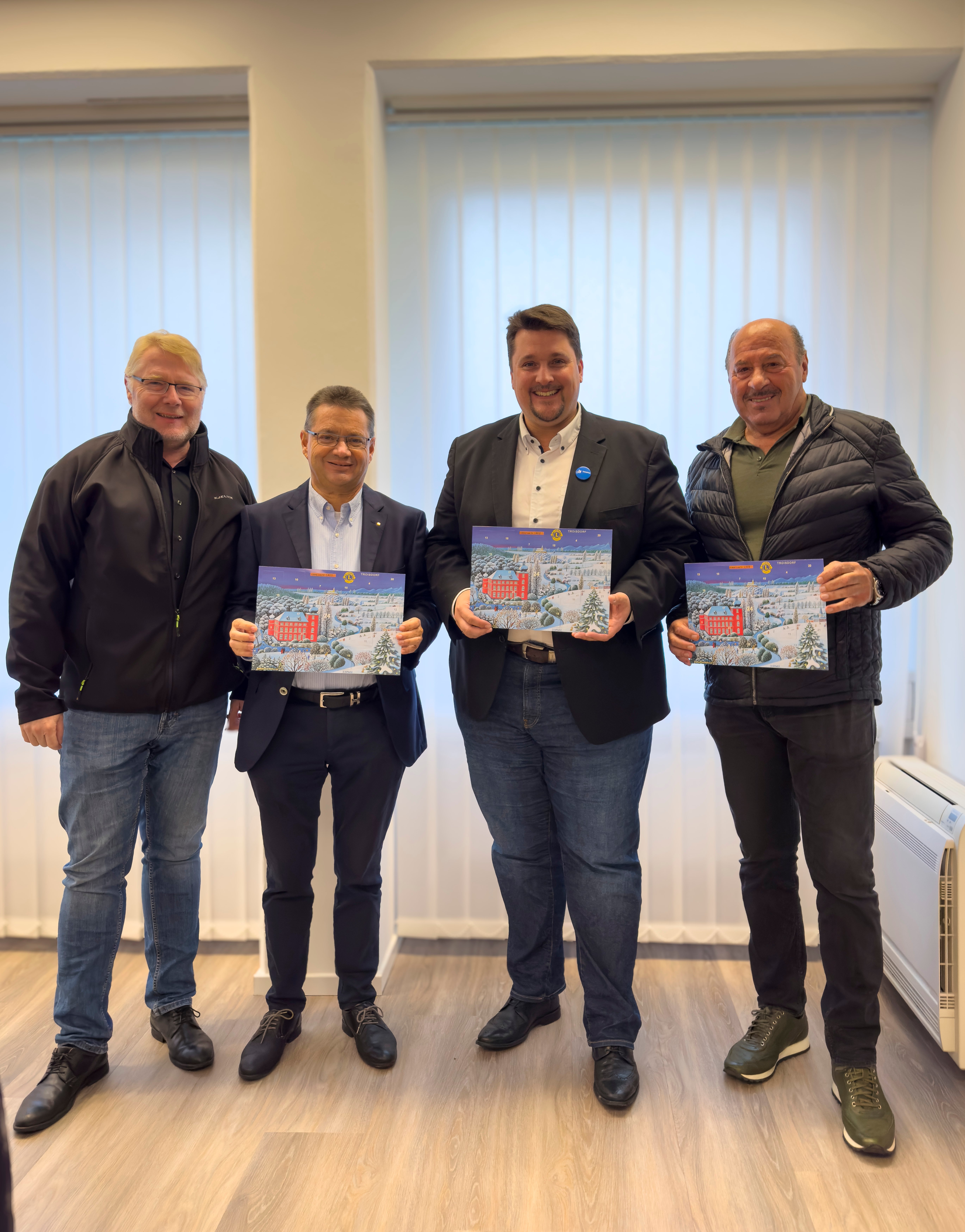 Künstler Josef Hawle, Bürgermeister Alexander Biber, Dr. Rolf Scheele, Präsident Lions Club Troisdorf und Jens Schäl, 1. Vizepräsident Lions Club Troisdorf präsentieren den Lions Club Kalender.